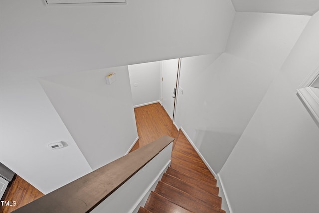 staircase with wood finished floors and baseboards