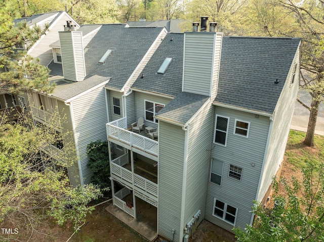 exterior space with a chimney and a shingled roof