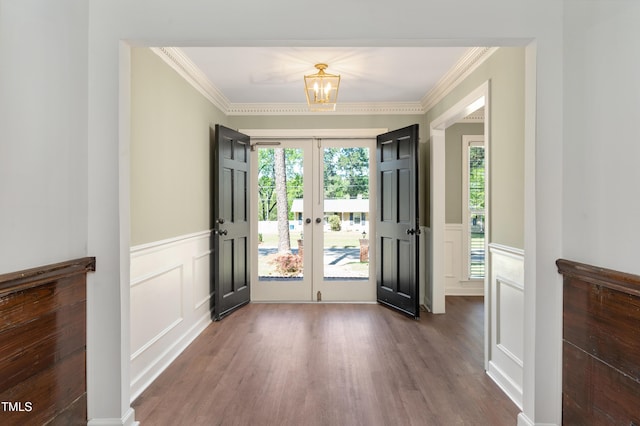 doorway to outside with a decorative wall, ornamental molding, dark wood-style flooring, french doors, and a wainscoted wall
