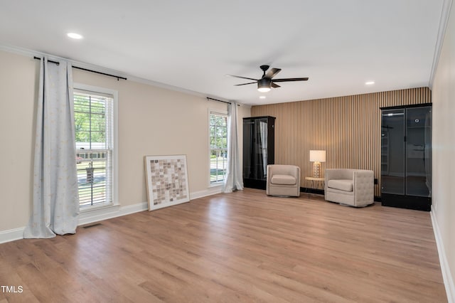 unfurnished room featuring light wood finished floors, visible vents, baseboards, and ceiling fan