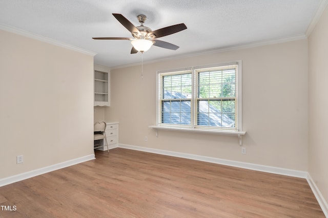 interior space with ceiling fan, baseboards, ornamental molding, and wood finished floors