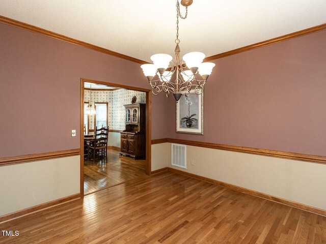 422 Old Scarborough Ln, Garner, NC 27529 - spare room featuring light wood-type flooring, ornamental molding, visible vents, a chandelier, and baseboards