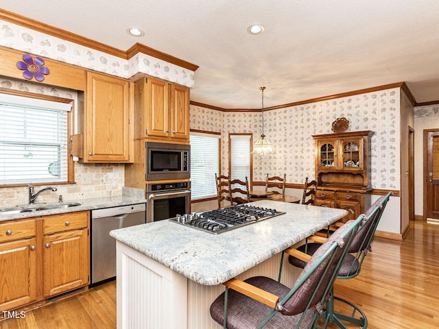 422 Old Scarborough Ln, Garner, NC 27529 - kitchen featuring crown molding, a sink, stainless steel appliances, wallpapered walls, and a breakfast bar area