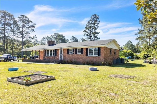 ranch-style home with brick siding, a chimney, a front lawn, and a vegetable garden
