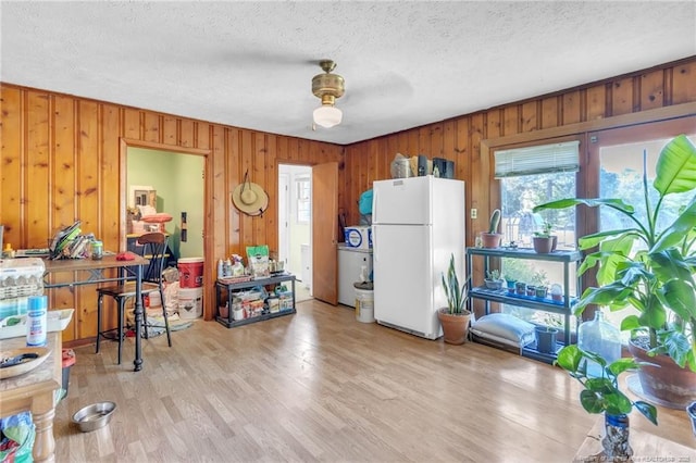 kitchen featuring freestanding refrigerator, plenty of natural light, and a textured ceiling