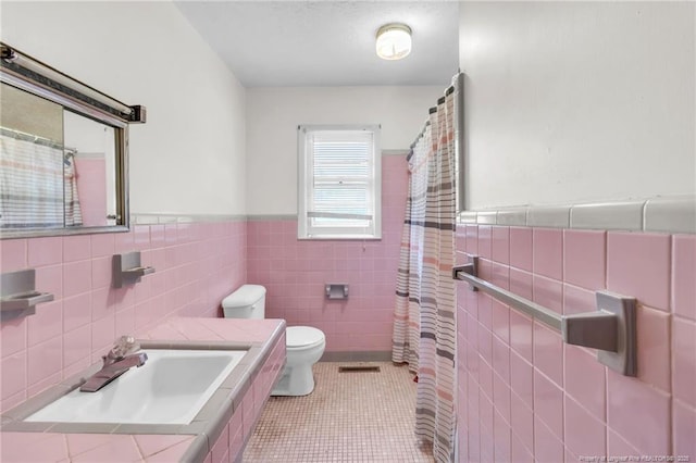 bathroom featuring a sink, toilet, tile walls, visible vents, and tile patterned flooring