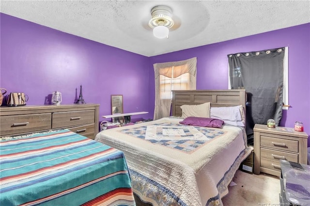 bedroom featuring a ceiling fan, carpet, and a textured ceiling