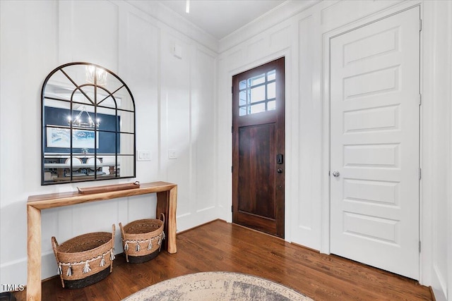 foyer featuring a decorative wall, ornamental molding, and wood finished floors