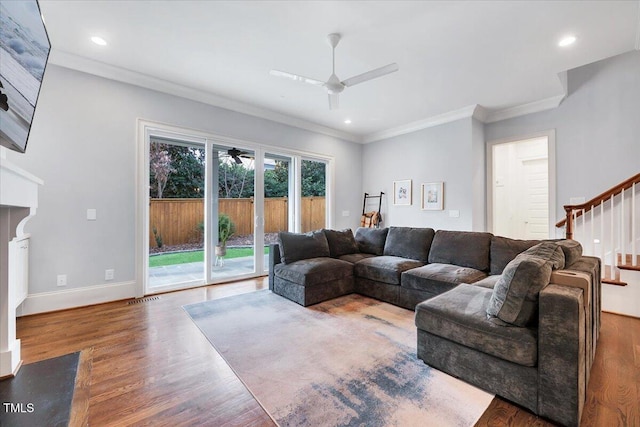 living room featuring a ceiling fan, crown molding, recessed lighting, wood finished floors, and stairs
