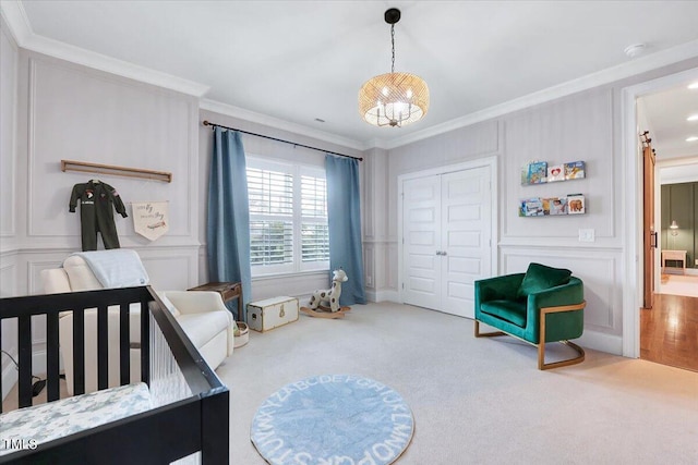bedroom with crown molding, a decorative wall, a closet, and carpet floors