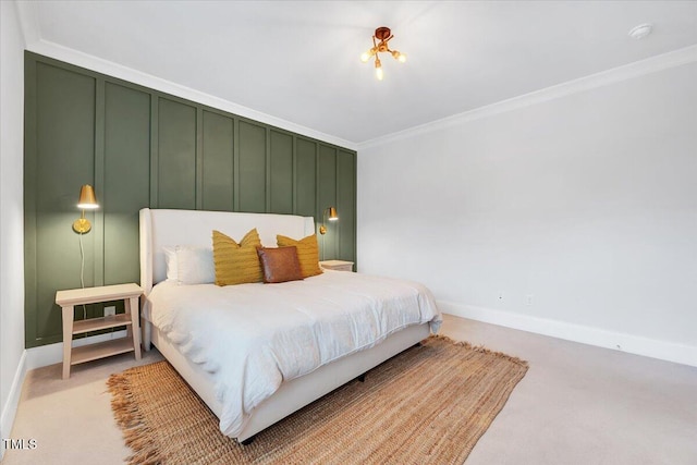 bedroom featuring a decorative wall, light colored carpet, baseboards, and ornamental molding