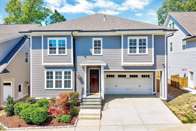 traditional home with driveway, a garage, and roof with shingles