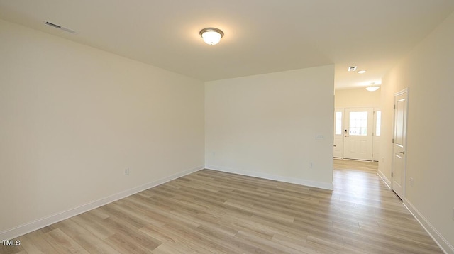 unfurnished room with light wood-type flooring, baseboards, and visible vents