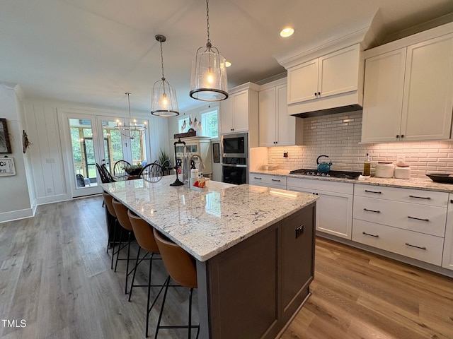 6521 Camellia Creek Dr, Raleigh, NC 27603 - kitchen with stainless steel appliances, healthy amount of natural light, a breakfast bar area, light wood-style flooring, and recessed lighting
