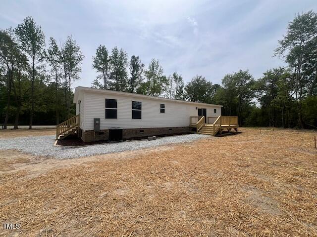rear view of house featuring crawl space, a wooden deck, and cooling unit