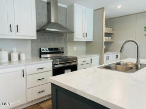 4285 Autry Mill Rd, Godwin, NC 28344 - kitchen with stainless steel electric range, wall chimney exhaust hood, light countertops, and white cabinets