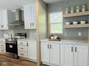 4285 Autry Mill Rd, Godwin, NC 28344 - kitchen featuring wall chimney range hood, stainless steel electric range oven, decorative backsplash, white cabinets, and light countertops