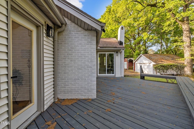 wooden deck with a storage shed and an outbuilding