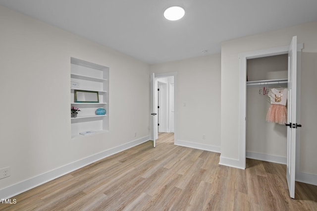 unfurnished bedroom with wood finished floors, baseboards, and a closet