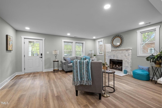 living room featuring visible vents, recessed lighting, light wood-type flooring, and a premium fireplace