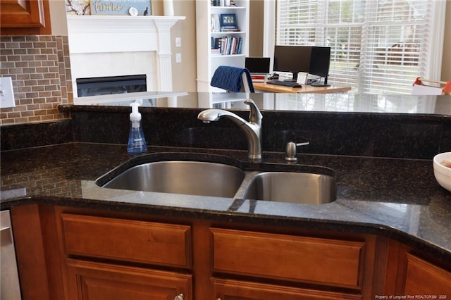 308 St Martins Pl, Fayetteville, NC 28311 - kitchen featuring brown cabinetry, dark stone countertops, and a sink