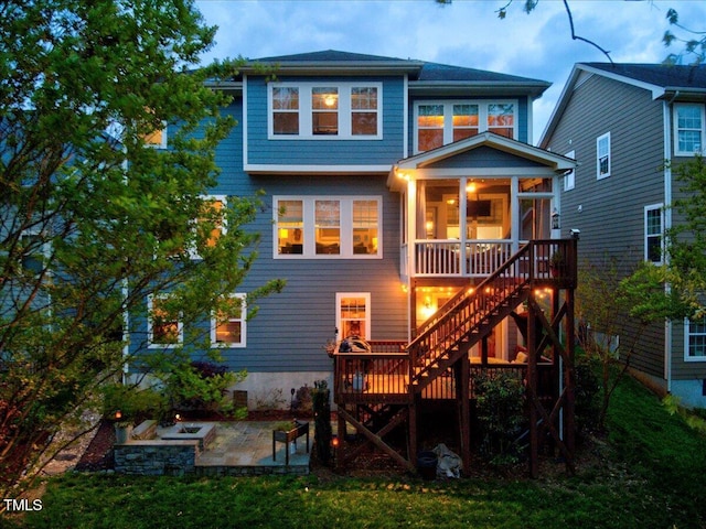 rear view of house featuring stairs, a patio, and a sunroom