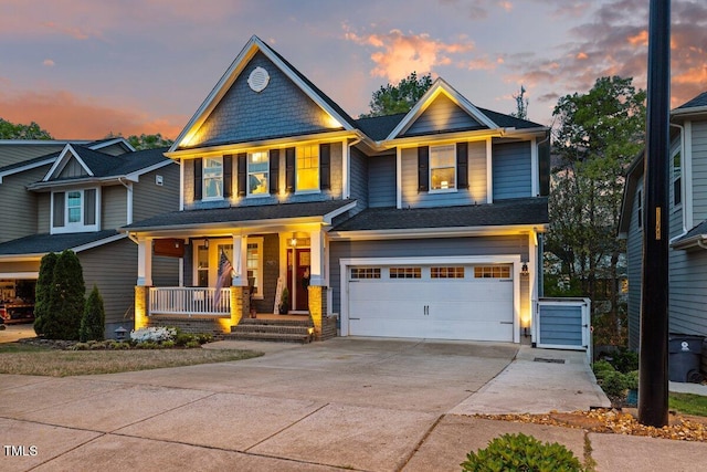 craftsman inspired home featuring covered porch, a garage, and concrete driveway