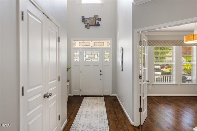 entrance foyer with dark wood finished floors, baseboards, and ornamental molding