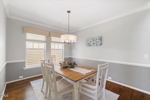 dining room with crown molding, baseboards, and wood finished floors