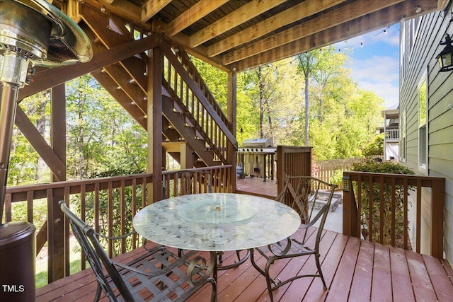 deck featuring outdoor dining area and stairs