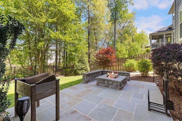 view of patio featuring an outdoor fire pit, a fenced backyard, and a ceiling fan