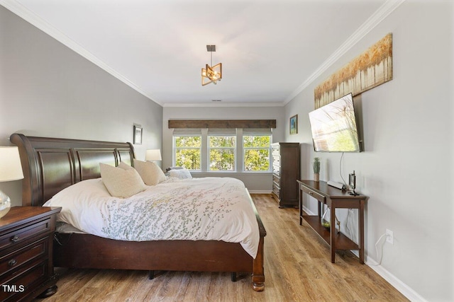 bedroom with light wood-type flooring, crown molding, and baseboards