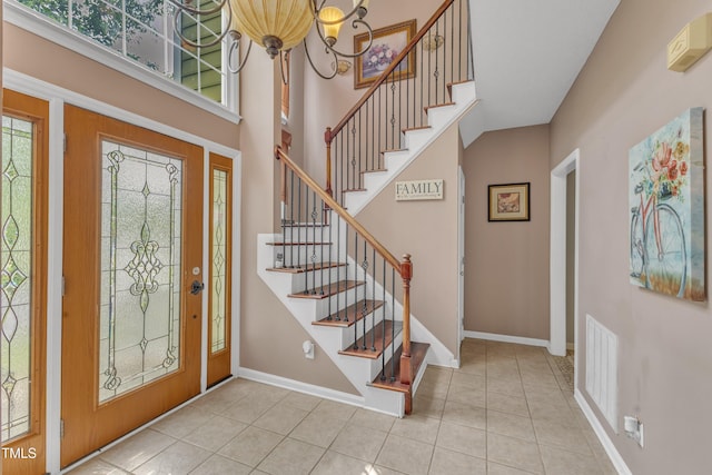 9332 Leslieshire Dr, Raleigh, NC 27615 - tiled entrance foyer with a chandelier, stairway, a high ceiling, and baseboards