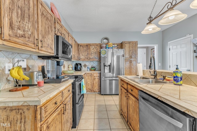9332 Leslieshire Dr, Raleigh, NC 27615 - kitchen with a textured ceiling, backsplash, stainless steel appliances, tile countertops, and a sink