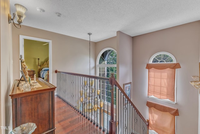 9332 Leslieshire Dr, Raleigh, NC 27615 - hallway featuring an upstairs landing, plenty of natural light, wood finished floors, and a textured ceiling