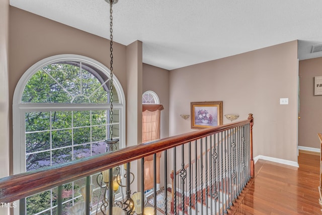 9332 Leslieshire Dr, Raleigh, NC 27615 - hallway featuring visible vents, baseboards, wood finished floors, and a textured ceiling