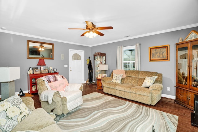 living area with wood finished floors, a ceiling fan, visible vents, and ornamental molding