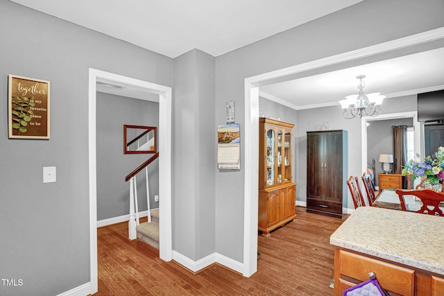 interior space featuring a chandelier, wood finished floors, baseboards, and stairway