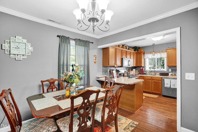 dining area with light wood finished floors, baseboards, visible vents, a chandelier, and crown molding