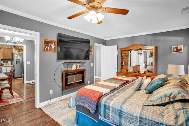 bedroom featuring wood finished floors, ornamental molding, baseboards, a fireplace, and stainless steel fridge