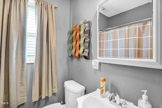 full bathroom featuring visible vents, toilet, and a sink