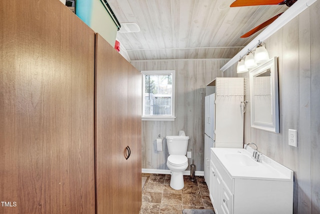 bathroom featuring baseboards, vanity, ceiling fan, and toilet