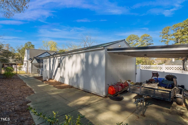 view of property exterior featuring fence and a patio area