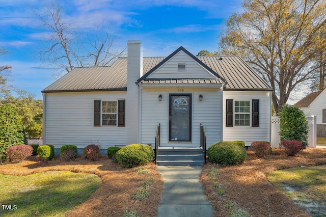 bungalow with a chimney and metal roof