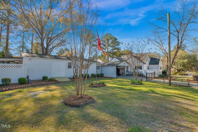 view of front of home featuring fence, an outbuilding, and a front yard