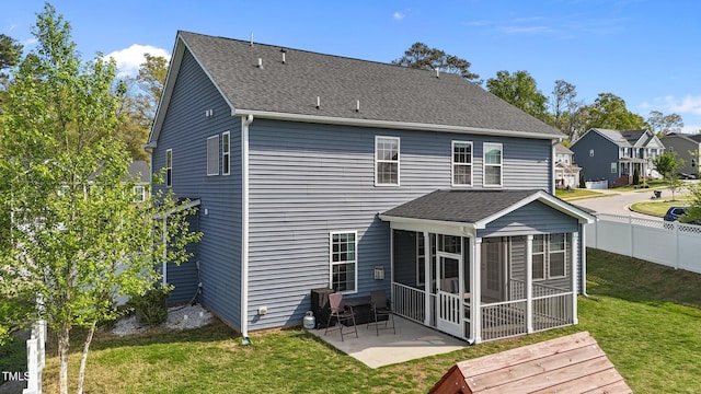 rear view of house featuring a sunroom, a patio, and roof with shingles