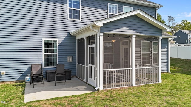 rear view of property featuring a sunroom and a patio area