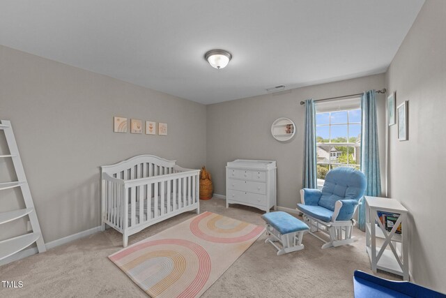bedroom with carpet flooring, baseboards, and a crib