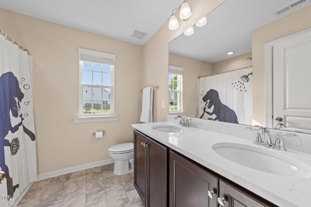 bathroom with baseboards, toilet, double vanity, and curtained shower