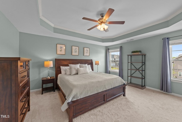 bedroom with a tray ceiling, light colored carpet, ornamental molding, and baseboards